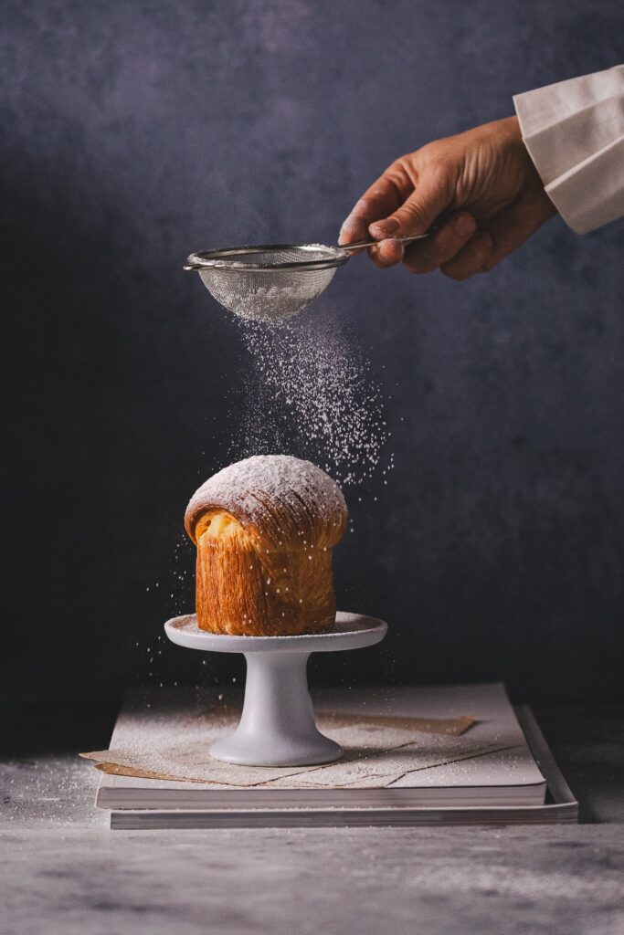 Fotografia kulinarna deser: cruffin z kremem waniliowym i cukrem pudrem, doskonała stylizacja piekarnictwa
