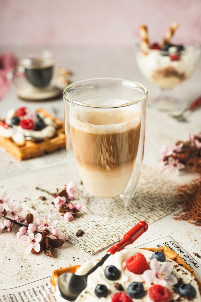 Fotografia kulinarna nap&oacute;j: kawa z słodkimi goframi, artystyczna aranżacja kawiarni