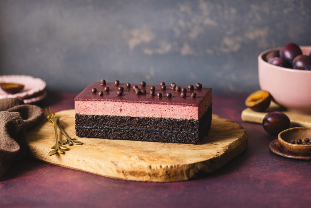 Fotografia kulinarna deseru: elegancka kostka deserowa ze śliwką i czekoladą, creative food styling