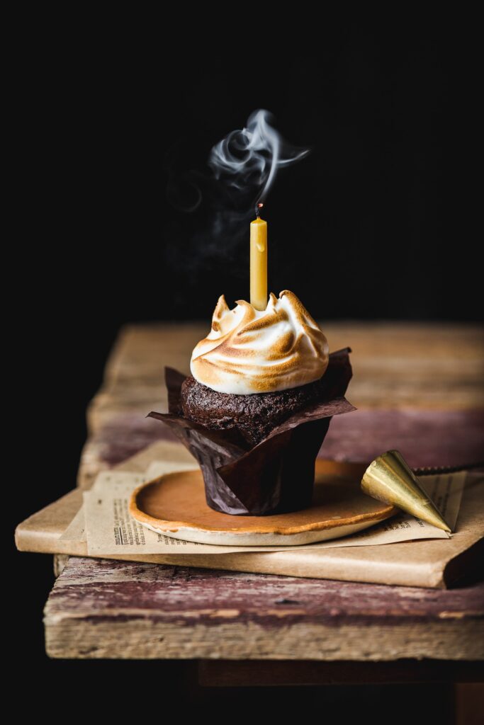 Fotografia kulinarna deser: czekoladowa muffinka ze świeczką, creative food styling