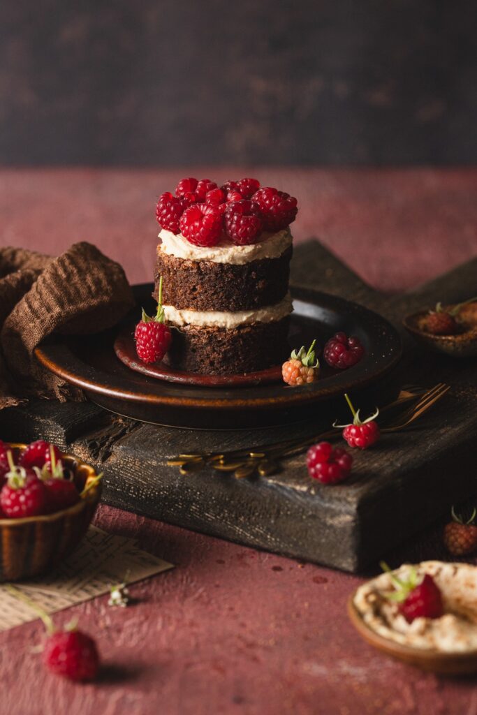 Fotografia kulinarna tort: elegancki torcik czekoladowy z malinami, creative food styling