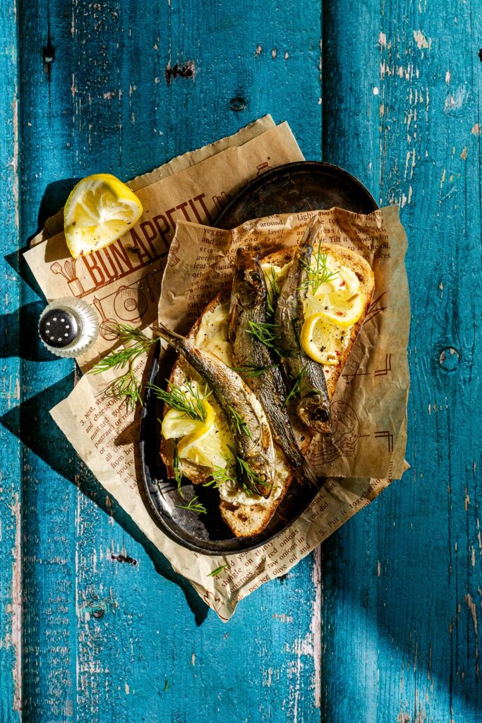 Fotografia kulinarna kanapka: kanapki z rybą szprotką i cytryną, profesjonalna sesja zdrowotnych potraw