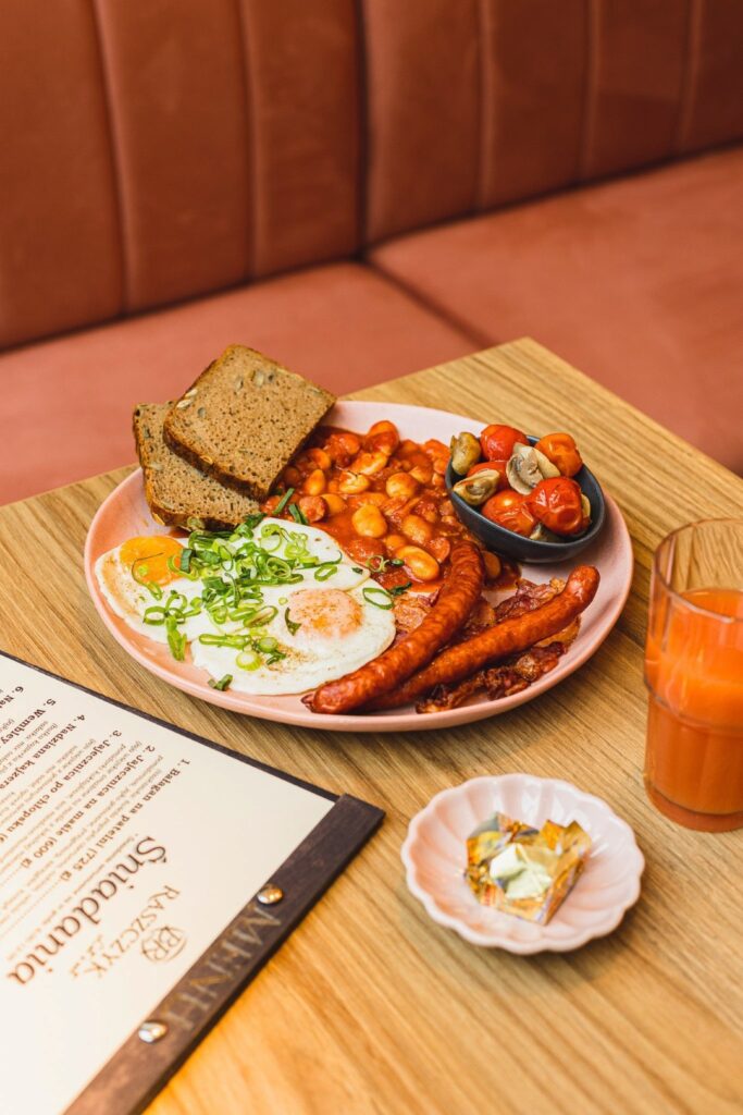 Fotografia kulinarna restauracja: śniadanie angielskie z jajkami i kiełbaską, profesjonalna sesja dla gastronomi