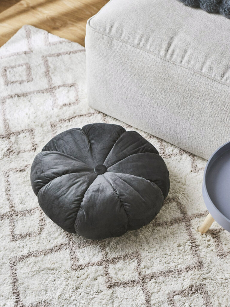 Sesja aranżacyjna home: ciemna dekoracyjna poduszka, nowoczesna stylizacja wnętrza