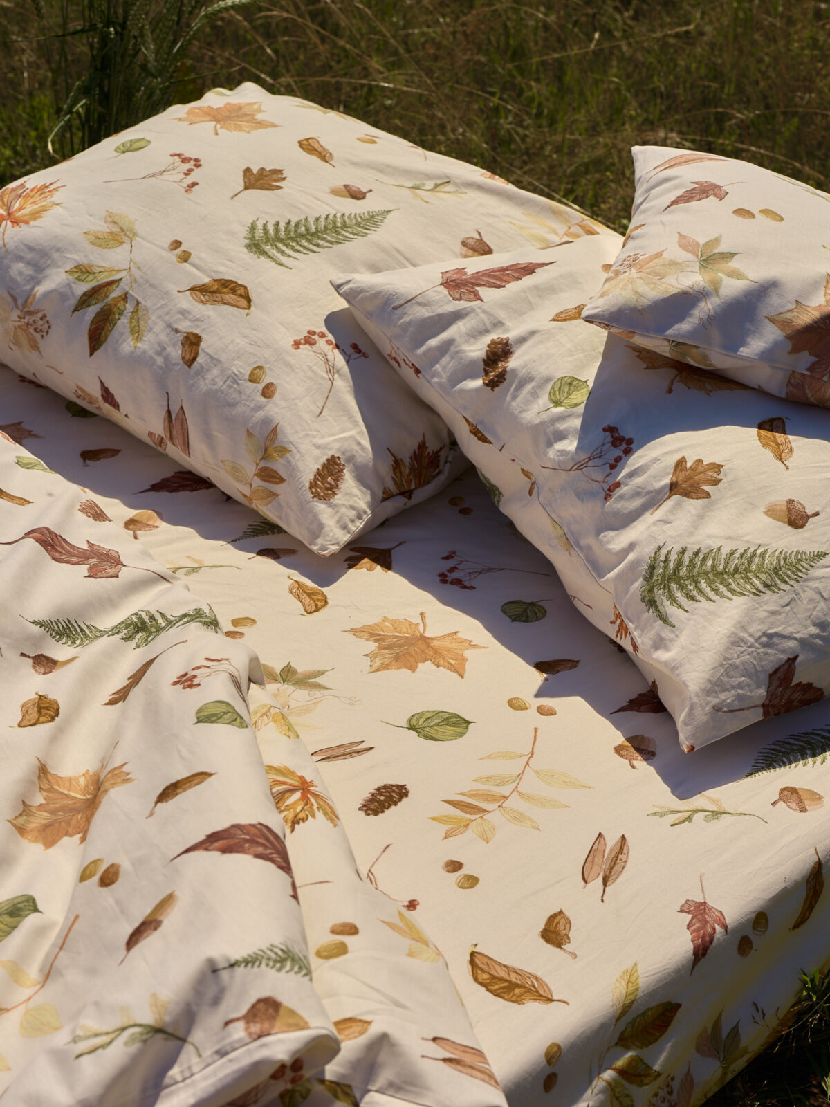 Sesja aranżacyjna Babie Lato: pościel na łące, naturalna stylizacja produkt&oacute;w tekstylnych