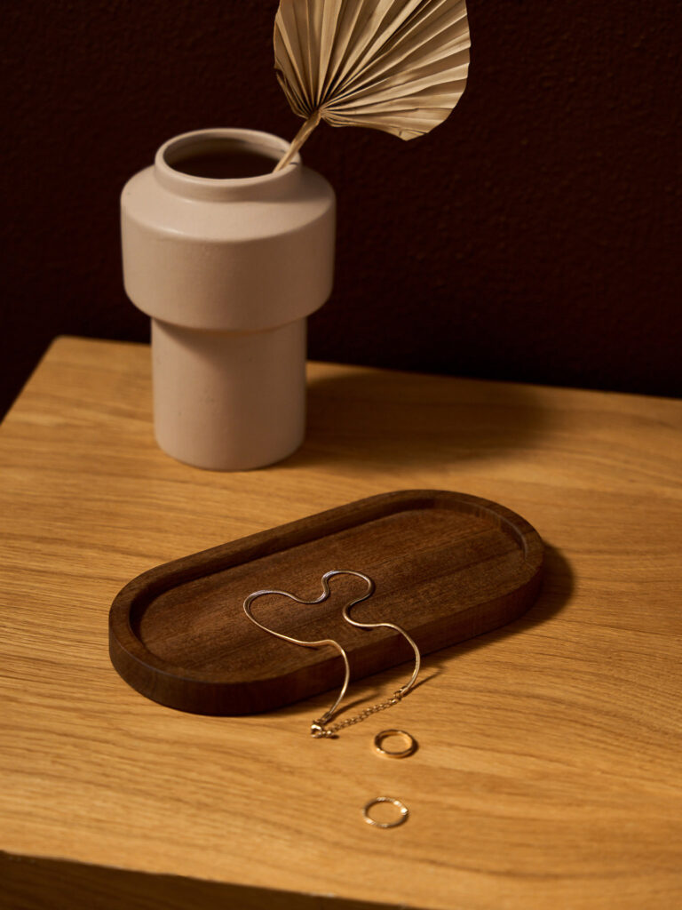 Sesja aranżacyjna home: biżuteria na drewnianej tacy, artystyczna fotografacja produkt&oacute;w lifestyle'owych